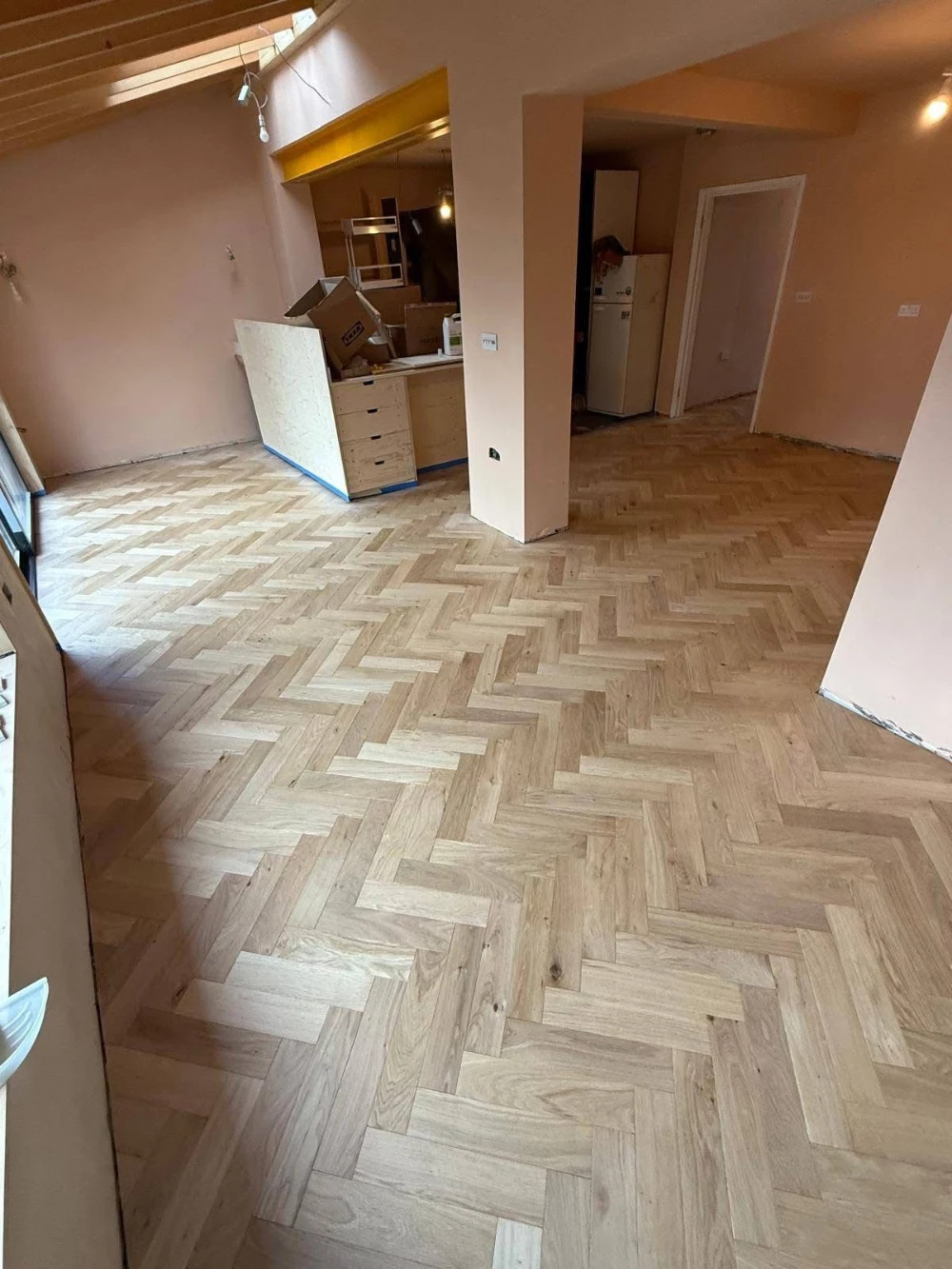 Open living space with a finished light herringbone hardwood floor