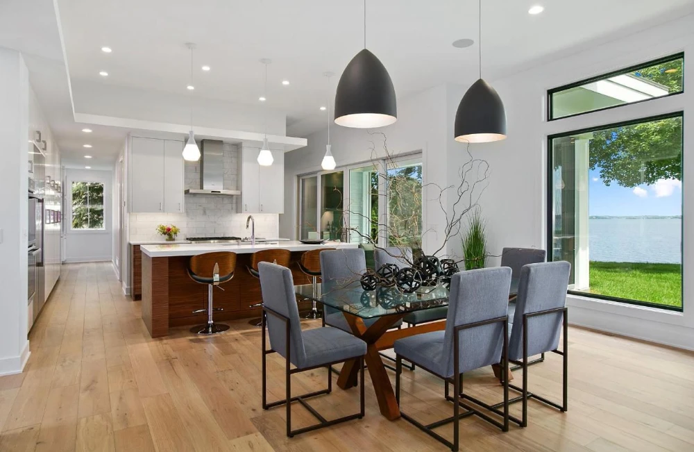 Recessed lighting and pendant fixtures in a modern open-concept kitchen and dining area